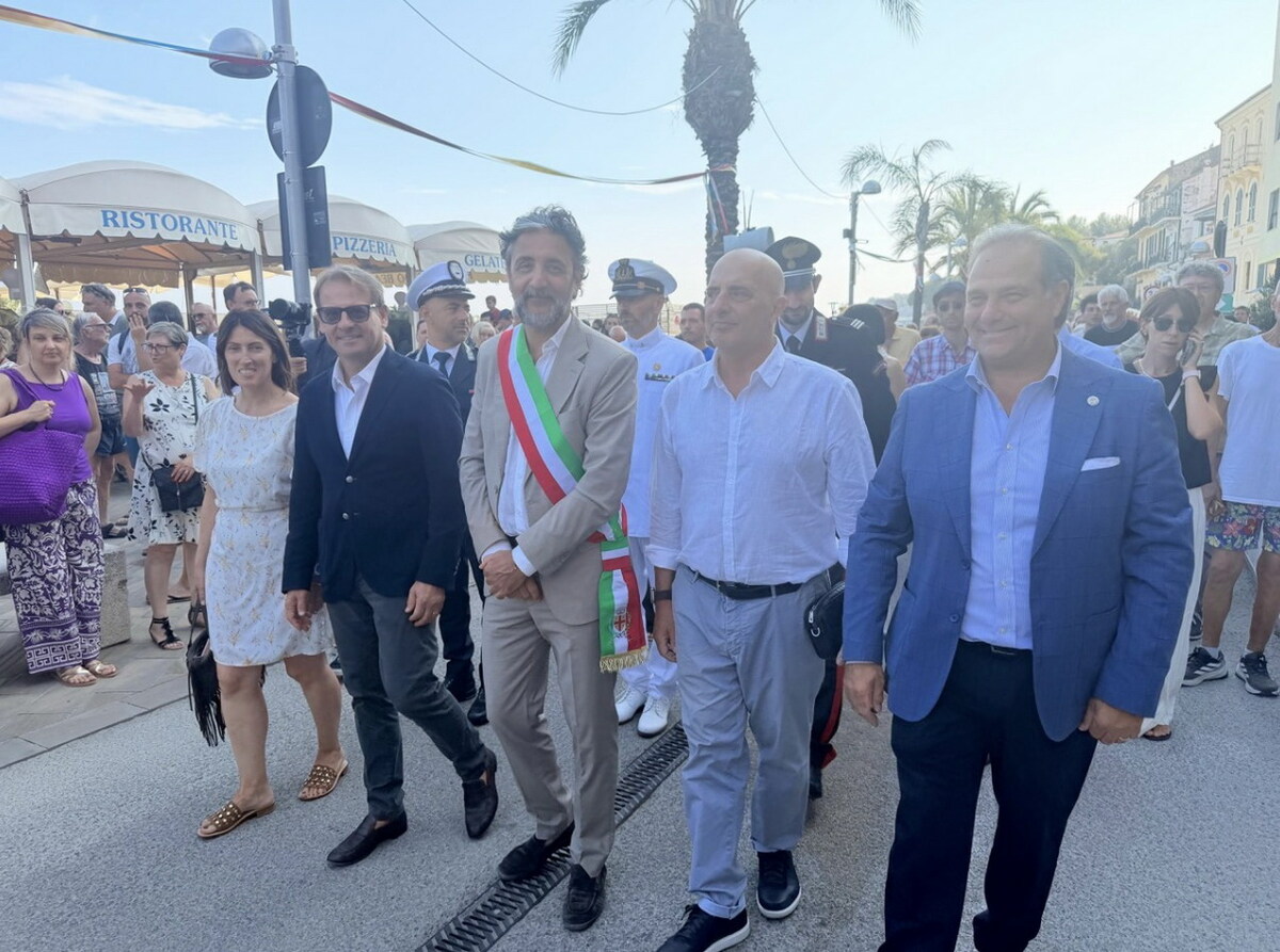 Processione religiosa con fedeli lungo le strade di Arma di Taggia, mare sullo sfondo durante la benedizione, immagine di approfondimento