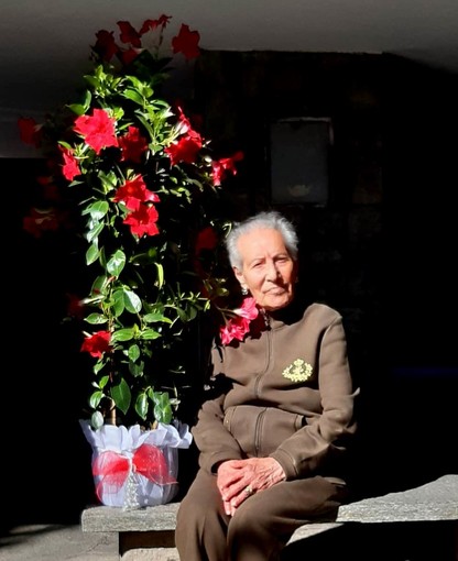 Nella foto la centenaria accanto al regalo floreale.