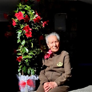 Nella foto la centenaria accanto al regalo floreale. Nella foto la centenaria accanto al regalo floreale.