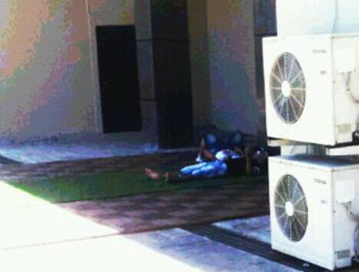 Sanremo: un clochard fa la 'siesta' dietro il solettore di piazza Colombo, la foto di un lettore Sanremo: un clochard fa la 'siesta' dietro il solettore di piazza Colombo, la foto di un lettore