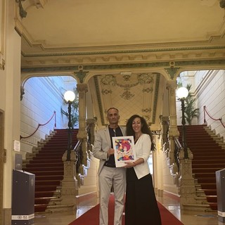 Houda Bakkali mostra l'opera d'arte durante la visita alla casa da gioco, insieme al presidente del consiglio comunale Alessandro Il Grande