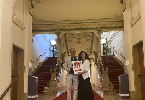 Houda Bakkali mostra l'opera d'arte durante la visita alla casa da gioco, insieme al presidente del consiglio comunale Alessandro Il Grande Houda Bakkali mostra l'opera d'arte durante la visita alla casa da gioco, insieme al presidente del consiglio comunale Alessandro Il Grande