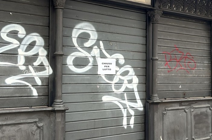 Il cartello sulla serranda di piazza Colombo