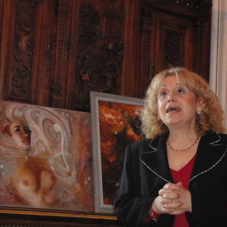 La poetessa Maria Salamone e sullo sfondo un'opera dell'artista Mad Jarova