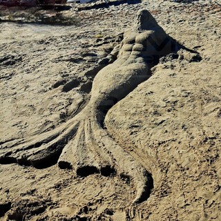 Arte in spiaggia ad Arma di Taggia: un giovane artista scolpisce Nettuno nella sabbia davanti al Ruffini (Foto)