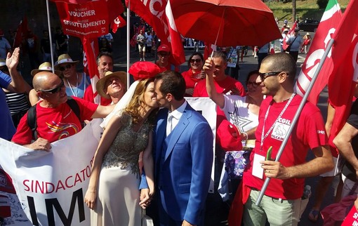 Lo Spi Cgil in corteo a Roma, e una coppia di sposini si bacia davanti al loro striscione (Foto)