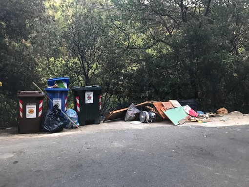 La spazzatura abbandonata vicino ai bidoni