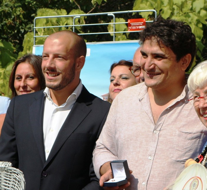 Mauro Coalgreco mentre riceve il premio del Gambero d'oro dal sindaco di Ventimiglia