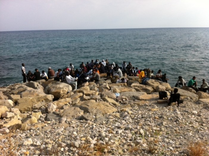 Un gruppo di migranti sugli scogli Un gruppo di migranti sugli scogli