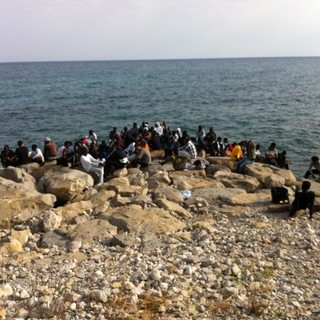Un gruppo di migranti sugli scogli Un gruppo di migranti sugli scogli
