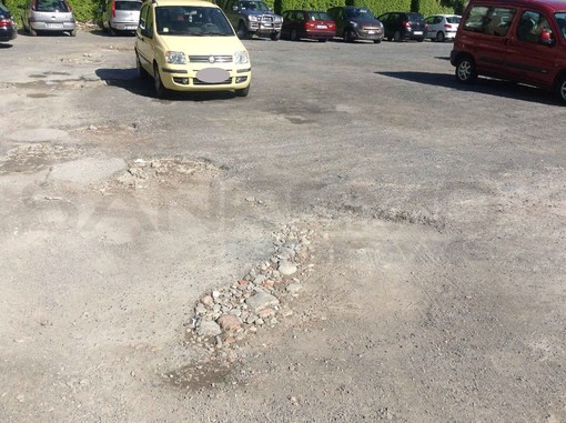 Taggia: degrado nel parcheggio Spinola, buche nell'asfalto e auto abbandonate lì da molti mesi