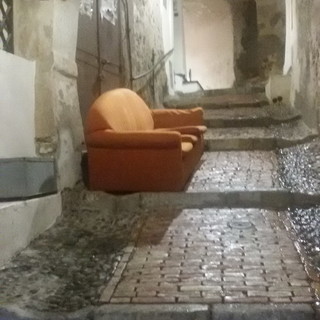 Sanremo: divano con angolo cottura in un carruggio del centro storico, l'ironica segnalazione del CdQ La Pigna