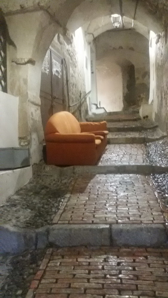 Sanremo: divano con angolo cottura in un carruggio del centro storico, l'ironica segnalazione del CdQ La Pigna