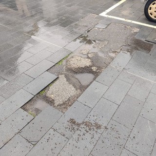 Taggia Arma: manto stradale pieno di buche, pietrisco e dislivelli in via Colombo, la segnalazione con foto di un residente