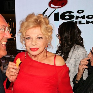 Sandra Milo mentre degusta una bugia di Vallebona con acqua di fior di arancio